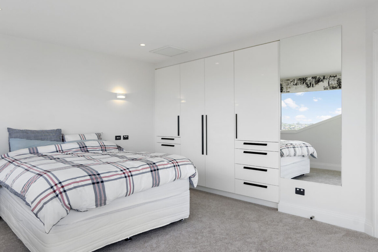 large bedroom with mirror, wardrobe and overhead lighting